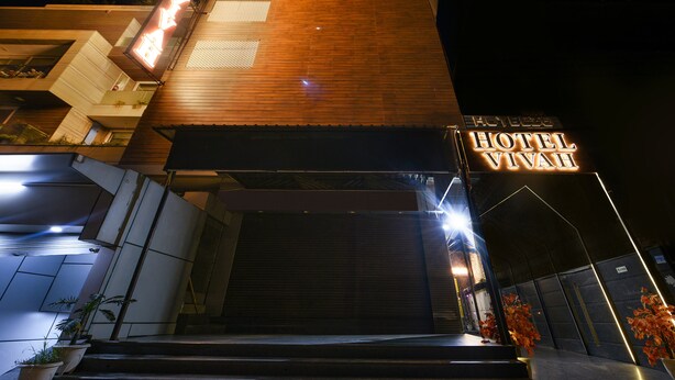 A modern hotel with a prominent 'HOTEL VIVAH' sign, a wooden facade, and a well-lit entrance. - Fabhotel Vivaah Inn (New Delhi)