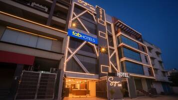 A multi-story building with a 'Sugar Inn Hotel' sign and a 'fahotels' sign.