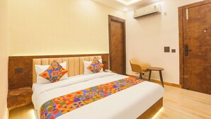 A modern hotel room with a large bed, a small desk, and a chair. - Fabhotel Sugar Inn (New Delhi)