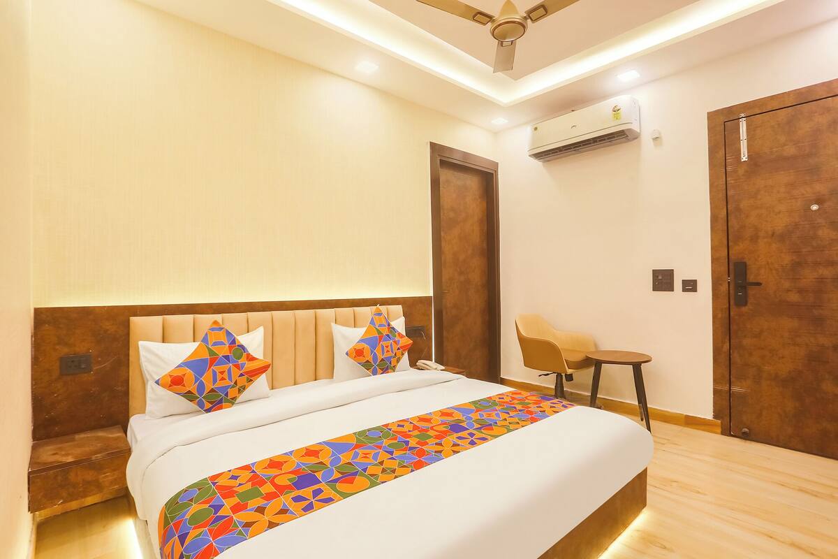 Una habitación de hotel moderna con una cama grande, un escritorio pequeño y una silla.