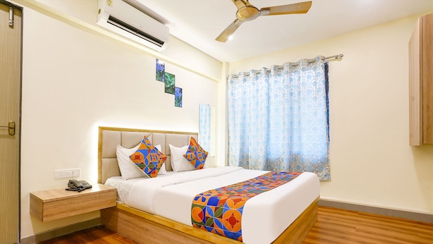 A bedroom with a bed, bedside table, nightstand, and an air conditioning unit. - Via 24/7 (Navi Mumbai)