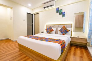 Cozy retreat with a neatly made bed, bedside table, and mirror.