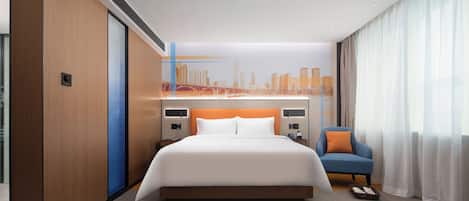 A modern hotel room with a large bed, a cityscape mural on the wall, a blue armchair, and a large window with sheer curtains.