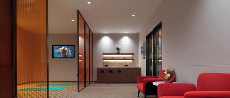 A modern reception area with a reception desk, seating, and a television.