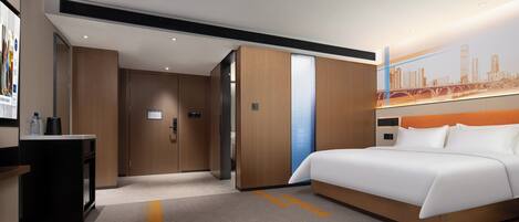 Una habitación de hotel moderna con una cama grande, un escritorio con una computadora y un mural con vistas a la ciudad en la pared.