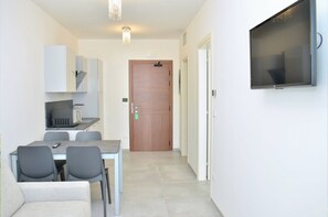 Una cocina moderna con microondas, una mesa de comedor con sillas y una puerta de madera.