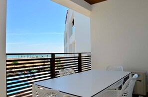 Ein Balkon mit Blick auf Strand und Poolbereich.