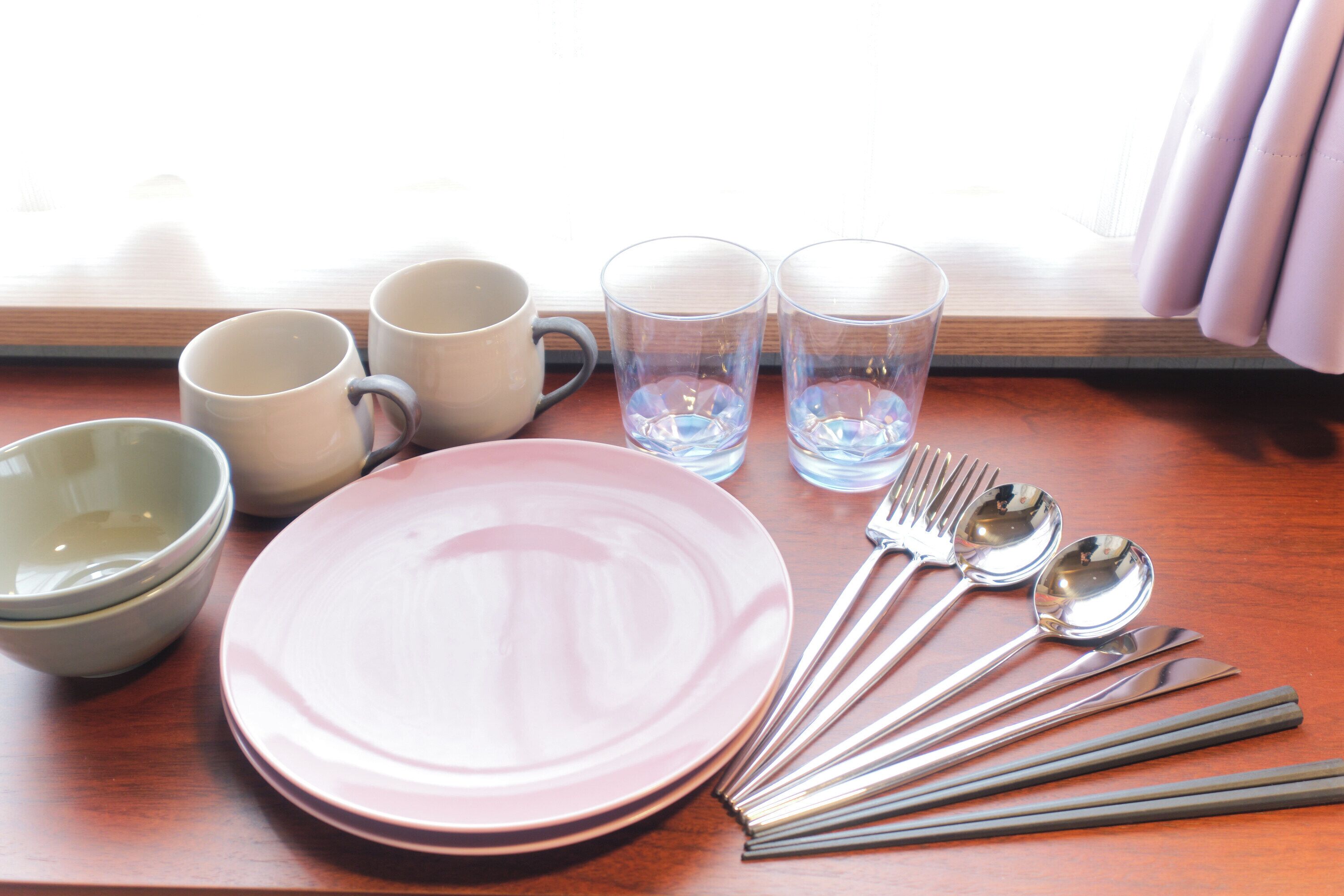 A table set with plates, bowls, cups, and cutlery.