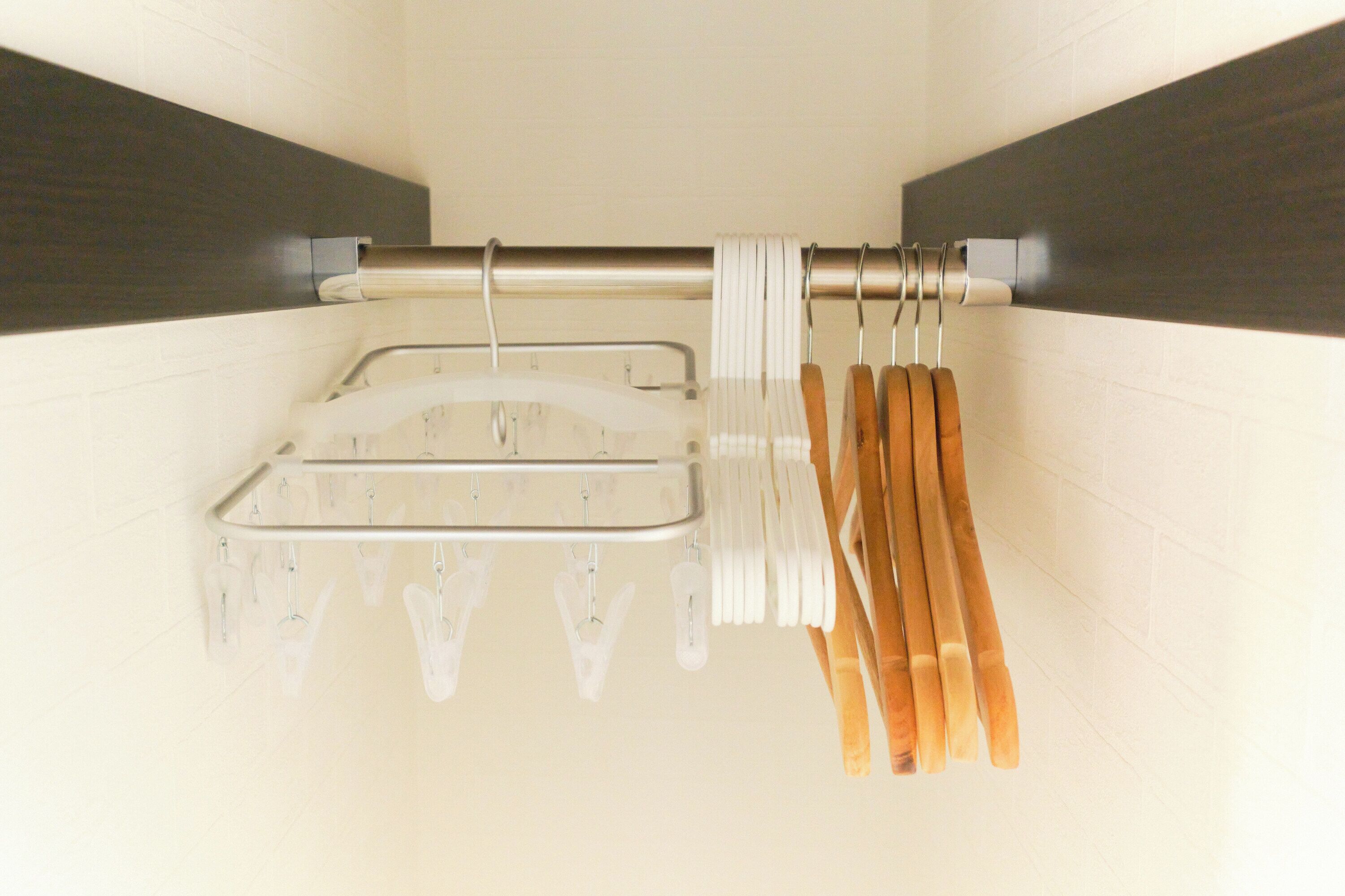 A bathroom with a towel rack holding white towels and wooden bath mats.