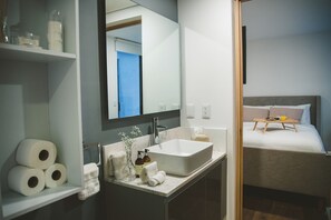 Enjoy a simple, functional space with a large bathroom sink, comfortable bed, and convenient storage.