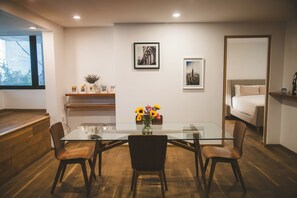 Cozy living space with a dining table, artworks, and a comfortable bed.