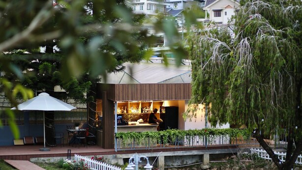 Ein moderner Außenbereich mit Bar, Sitzgelegenheiten und Flussblick.