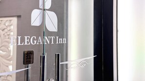 A glass door with the logo and name of the Elegant Inn. - Kaiyue Inn (Hualien City)