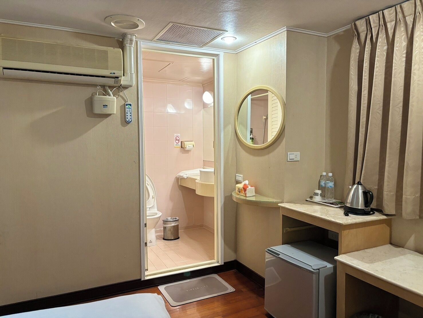 A compact hotel bathroom with a shower, toilet, and sink.