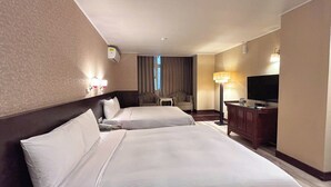 A hotel room with two beds, a TV, a desk, and a lamp. - Kaiyue Inn (Hualien City)