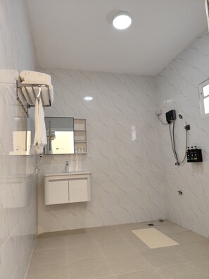 Experience a clean and luxurious bathroom with a vanity, mirror, and handheld showerhead.