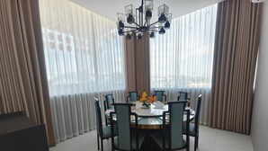 Uma área de refeições com mesa redonda, cadeiras e um candelabro.