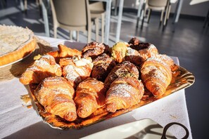 Una bandeja con varios pasteles, incluyendo croissants y otras delicias horneadas, sobre una mesa.