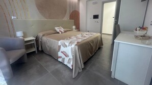Una habitación de hotel moderna con una cama grande, un escritorio y una silla.