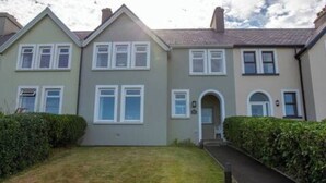 A row of two-story houses with a front lawn and hedges. - Paddy's Atlantic View! Home for 8 in Waterville! (Waterville)