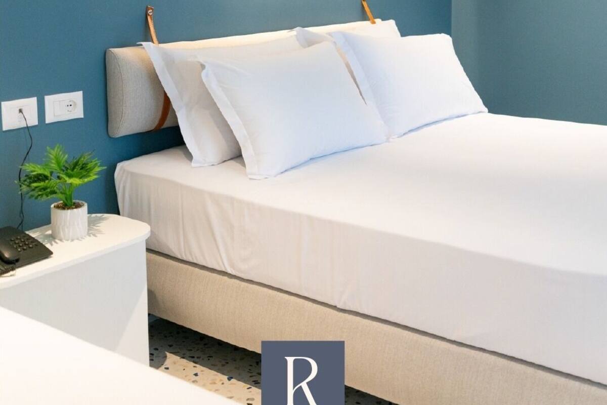 Ein Schlafzimmer mit Bett, Nachttisch und Wandleuchte.