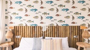 A bedroom with a wooden headboard, white bedding, and striped pillows.