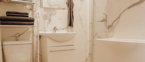 Un baño moderno con inodoro, lavabo y ducha.