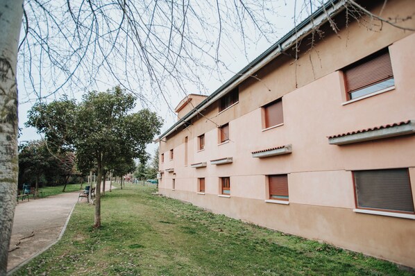 A building with multiple windows and a paved walkway.