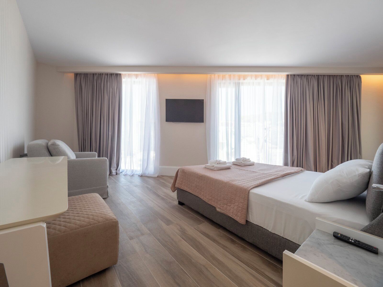 Une chambre d’hôtel avec un lit, un bureau, une chaise et un téléviseur.