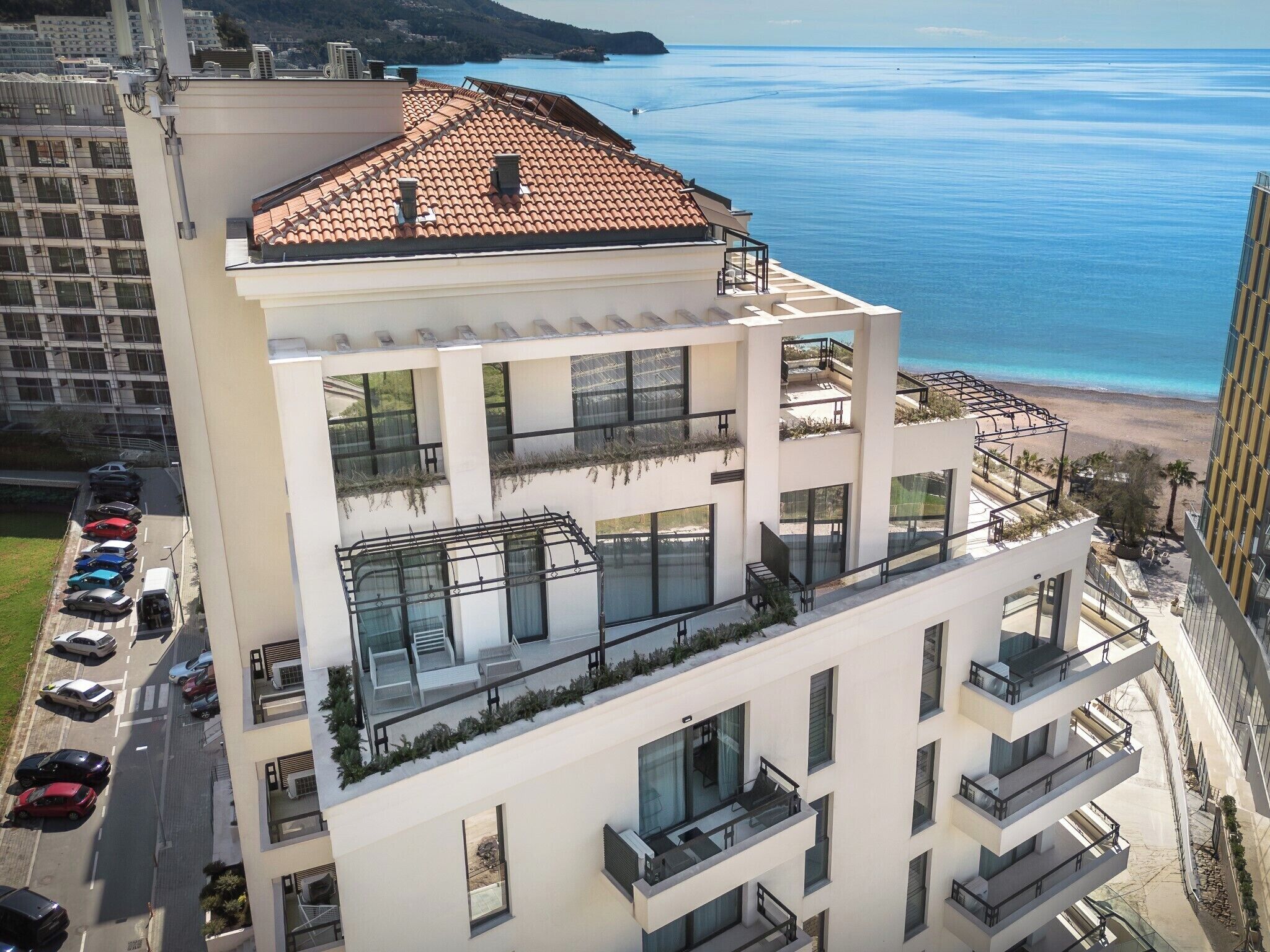 A multi-story building with balconies overlooking a beach.