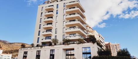 A tall, modern hotel with multiple balconies and a sign reading "CASA AL MARE".