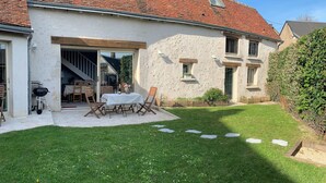 A house with a covered patio, a barbecue, and a well-maintained lawn. - Charming house close to the Loire châteaux (Baule)