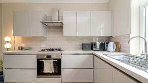 A compact kitchen with a built-in oven, a microwave, a toaster, and a sink. - Modern Apex Flat / King Bed/3 Guests/ Parking/WiFi (Argyll and Bute Council)