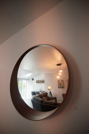 Contemporary living room with a sofa, dining table, and lamp.