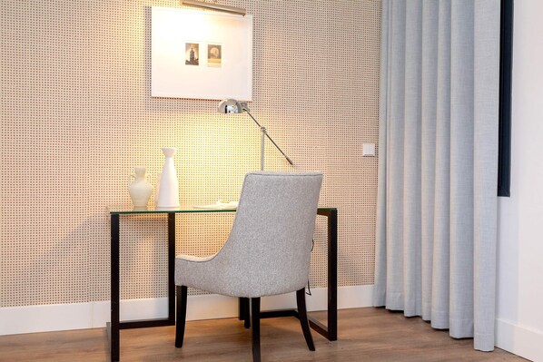 A modern room with a glass desk, a grey chair, a white vase, and a picture frame on the wall. - Genteel Home Betis 67 (Seville)