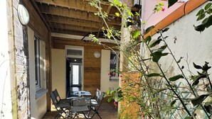 A wooden deck with a table and chairs, surrounded by plants and a metal fence. - Apart 50m² 5 People 2 Bedrooms –Town, Train, Beach few mn (La Bernerie-en-Retz)