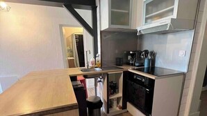 A compact kitchen with a wooden countertop, a built-in oven, and a microwave. - Apart 50m² 5 People 2 Bedrooms –Town, Train, Beach few mn (La Bernerie-en-Retz)
