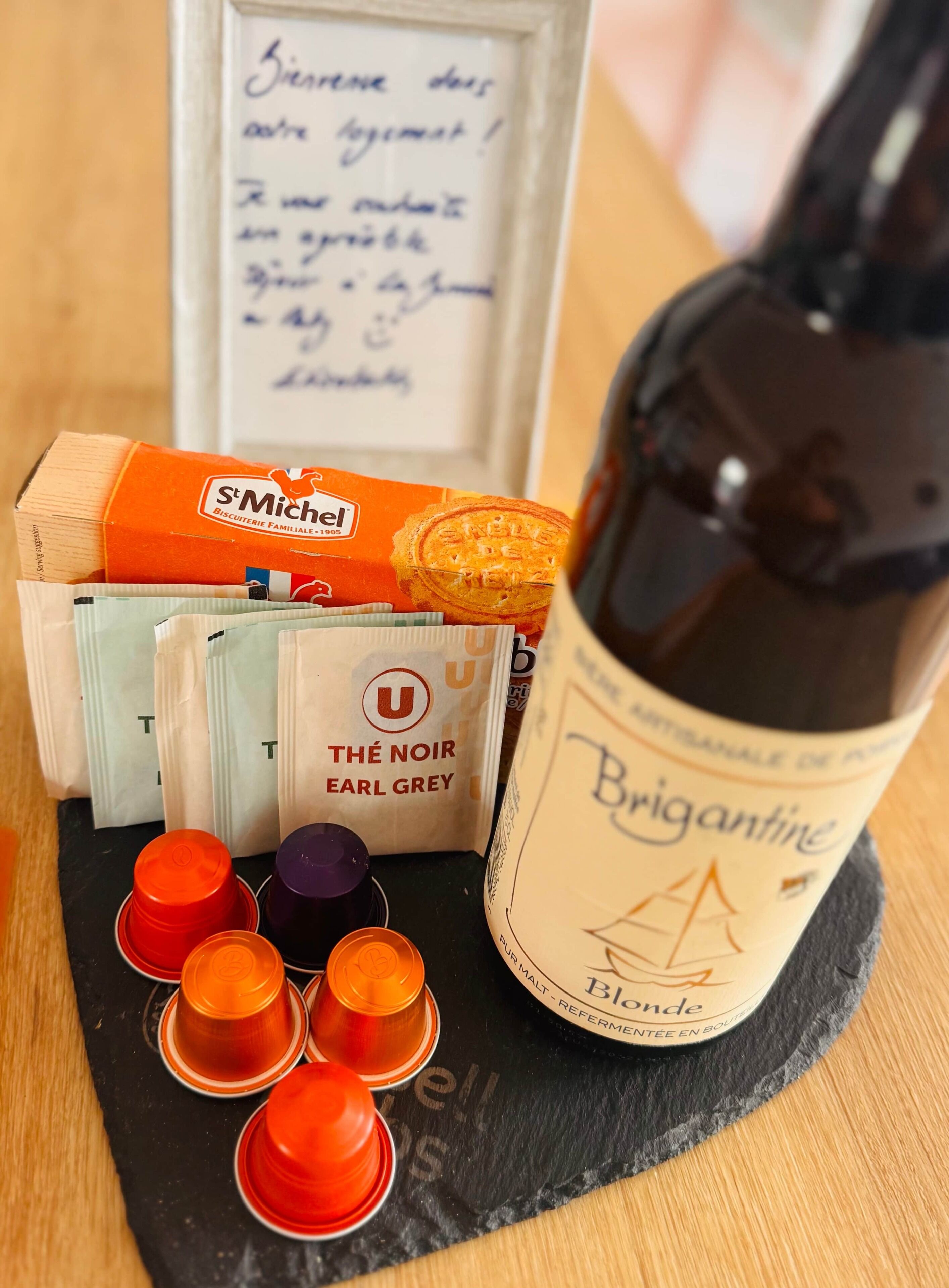 A bottle of Brignatine Blonde wine, a box of St. Michel biscuits, and several bags of The Noir Earl Grey tea.