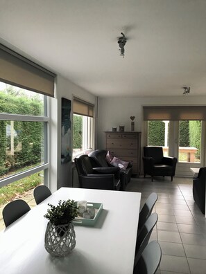 Enjoy meals in this dining area with a view, featuring a spacious table and comfortable seating.