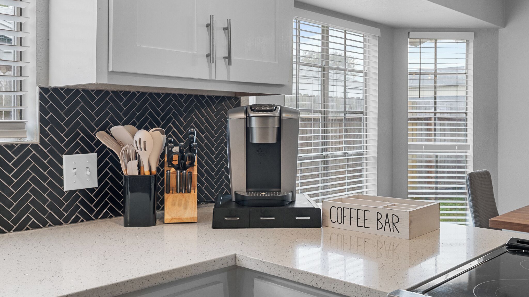 Une cuisine moderne  équipée d’un coin café, d’une machine à café et d’ustensiles de cuisine.