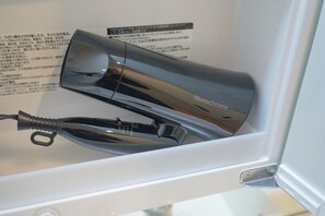 Een bad/douchecombinatie, een haardroger, handdoeken, shampoo