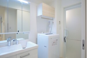 Bañera con ducha, secador de pelo, toallas, shampoo