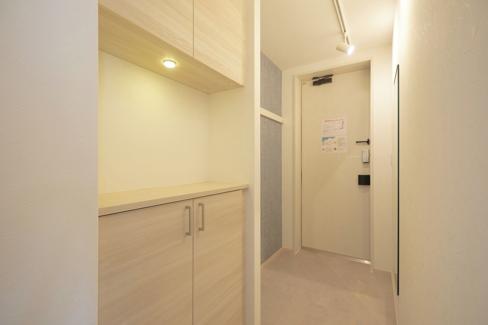 Um corredor estreito com um armário de madeira e uma porta com uma placa.