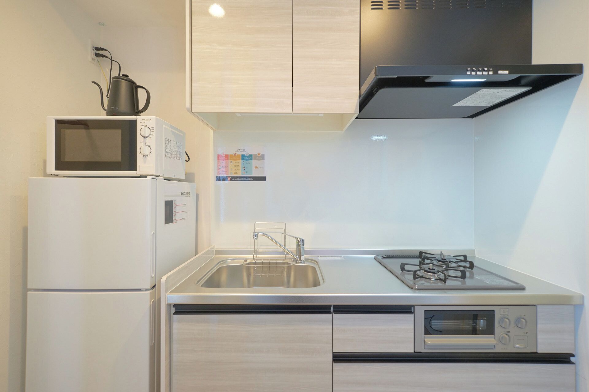 A compact kitchen with a microwave, refrigerator, sink, stove, and oven.