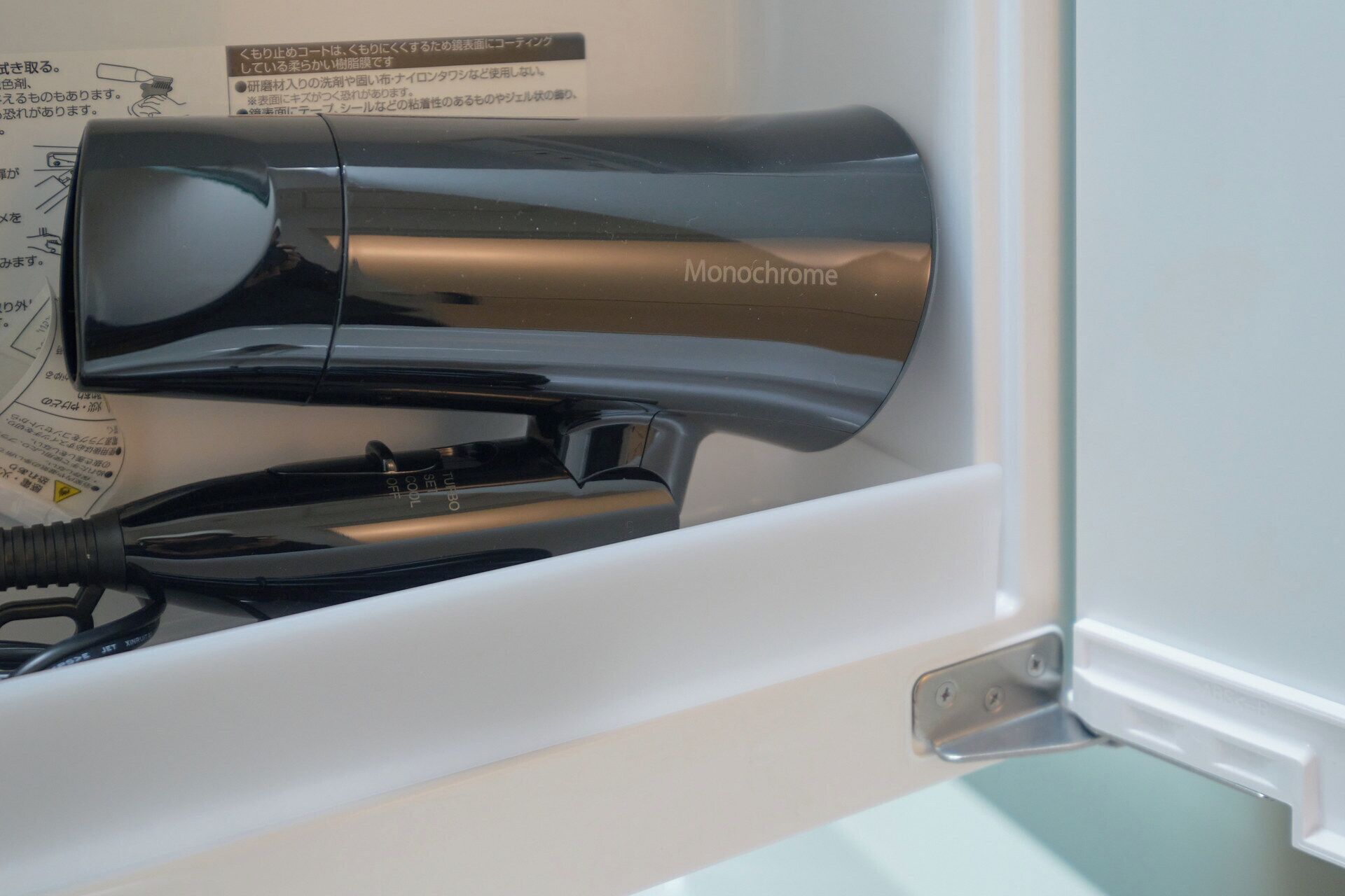 A hair dryer with the brand name 'Monochrome' in a white interior space.