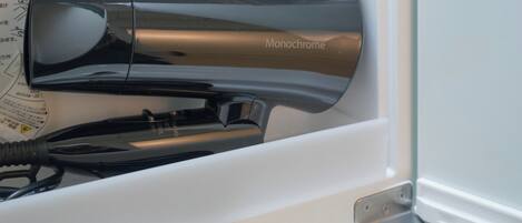 A hair dryer with the brand name 'Monochrome' in a white interior space.