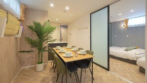 A modern hotel room with a dining area, a bed, and a large potted plant. - Z LAND Enoshima by Tranova (Fujisawa)