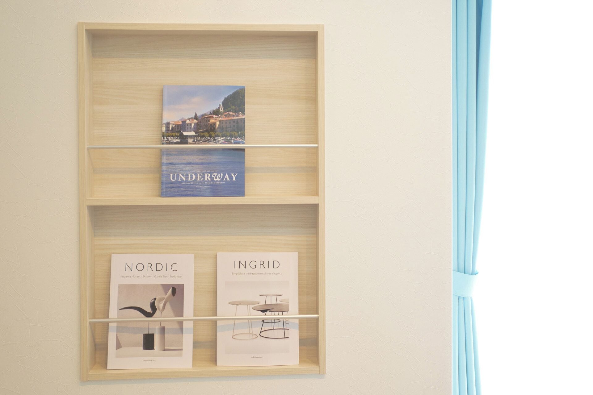 A wooden shelf with books and framed artwork.