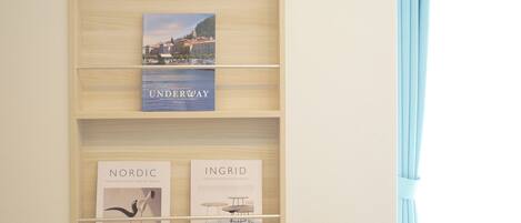 A wooden shelf with books and framed artwork.