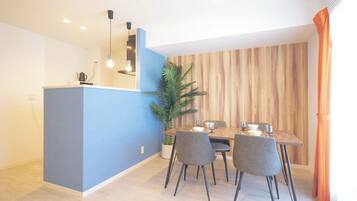 Un comedor moderno con una pared azul de acento, un revestimiento de madera y una mesa de comedor con sillas.
